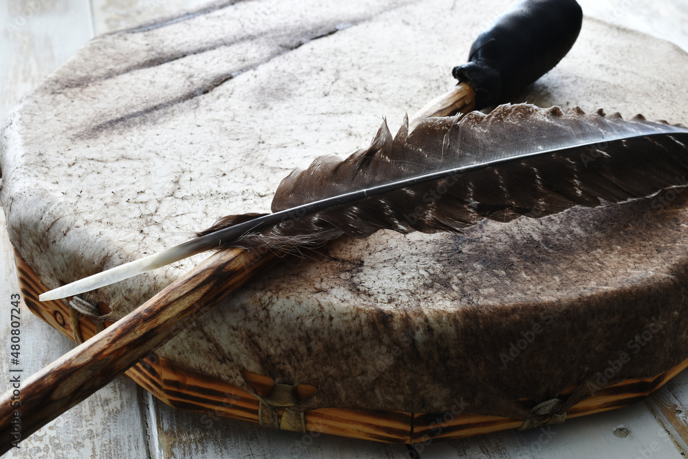 Ταπετσαρία A close up image of a hand made leather meditation drum with sacred feather and drum stick