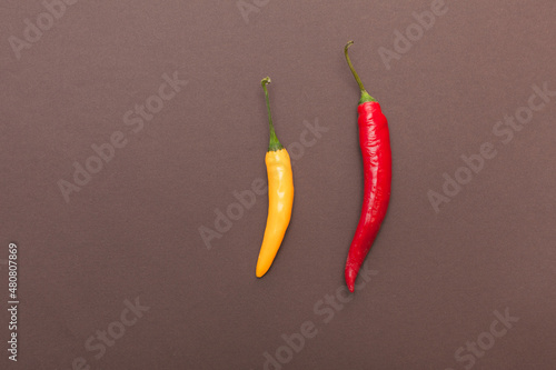 red and yellow chili peppers on brown background