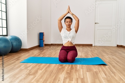 Fototapeta Naklejka Na Ścianę i Meble -  Young hispanic woman training yoga at sport center