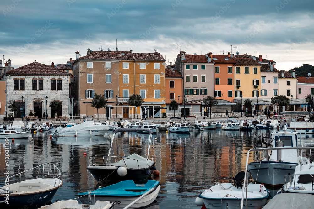 Beautiful, colorful houses, traditional to Istria peninsula of Croatia, in the famous tourist town of Rovinj, next to the town port full of boats