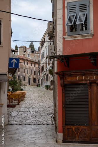 Colorful, stone paved Rovinj city streets, going up the hill with no people outside during cold, winter season