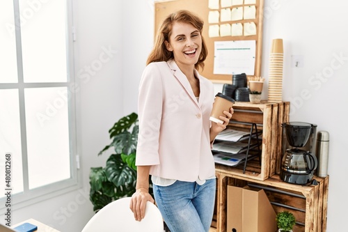 Young caucasian businesswoman smiling happy drinking coffee at the office. © Krakenimages.com