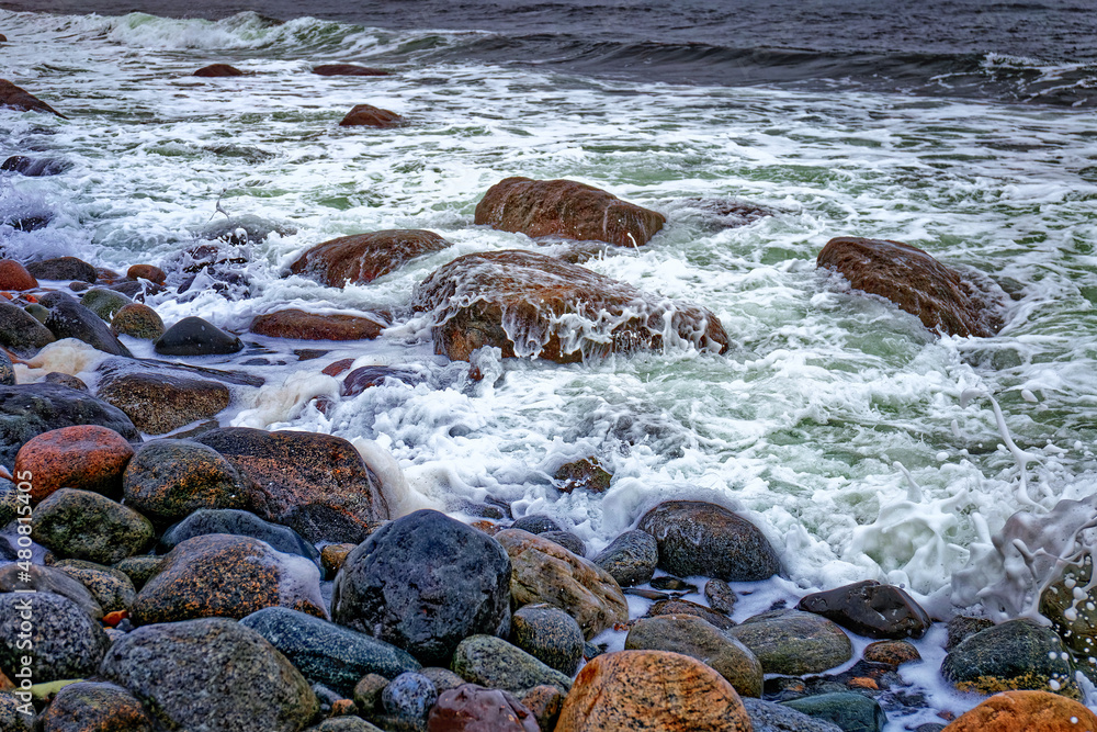 Obraz premium Stormy and cloudy day seascape with colorful rolling stones on the Molen beach .UNESCO Global Geopark near Larvik, Vestfold County, Norway