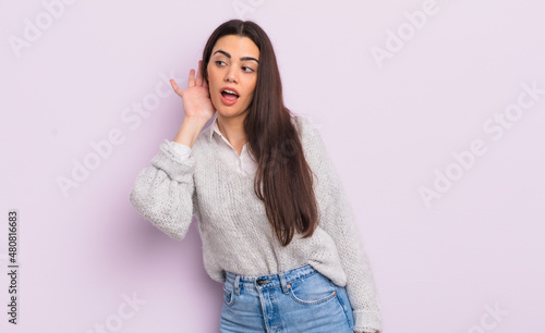 pretty young woman smiling, looking curiously to the side, trying to listen to gossip or overhearing a secret photo