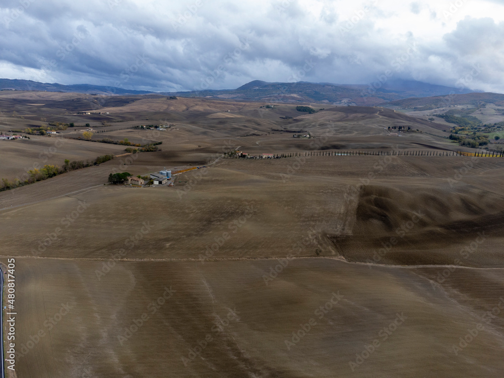 Aerial view on hills of Val d'Orcia, Tuscany, Italy. Tuscan landscape with ploughed fields in autumn.