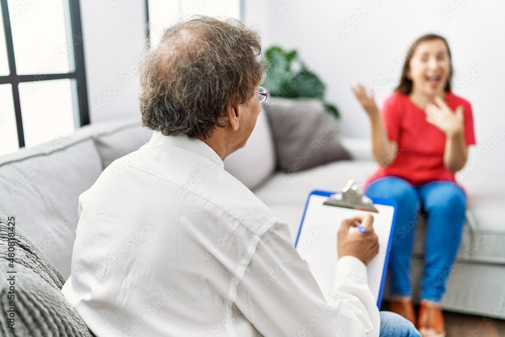 Middle age man and woman smiling confident having psychology session at home Middle age man and woman smiling confident having psychology session at home