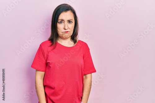 Middle age hispanic woman wearing casual clothes depressed and worry for distress, crying angry and afraid. sad expression.