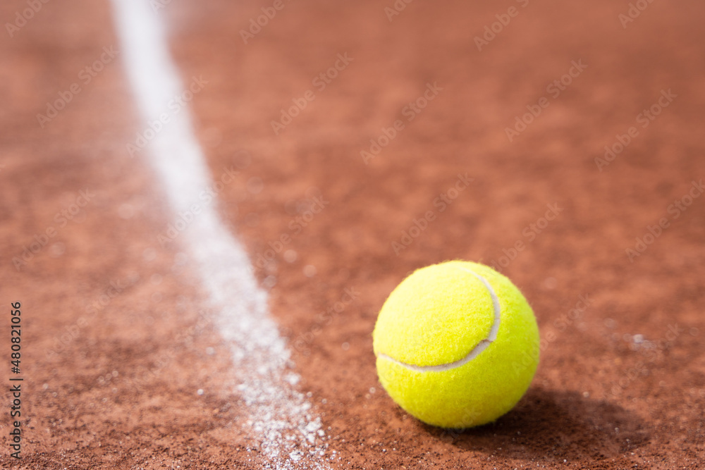 Tennis ball close to white line on clay court. Sports tournament competition, in out concepts