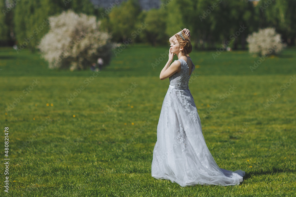 The beautiful woman in a dress in the field.