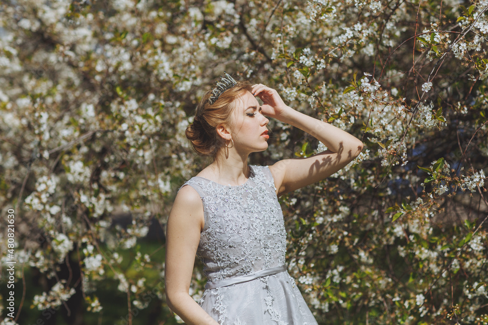 The beautiful woman in a dress in the blooming gardens. The beautiful woman in a dress in the blooming gardens.