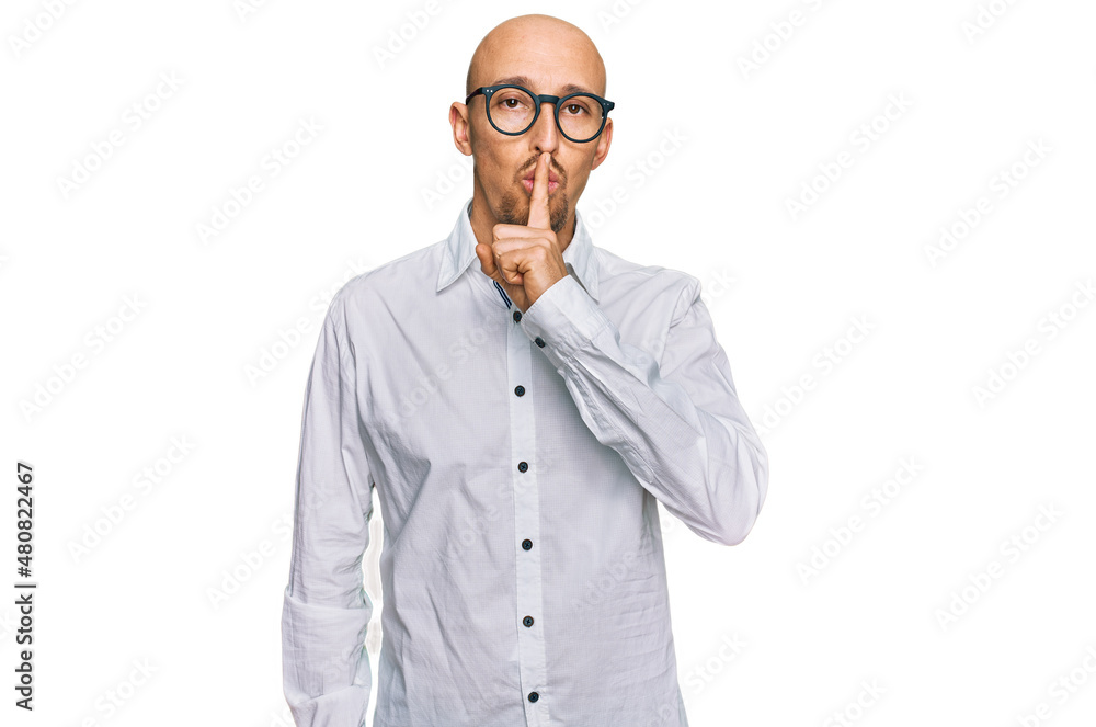 Bald man with beard wearing business shirt and glasses asking to be quiet with finger on lips. silence and secret concept. Bald man with beard wearing business shirt and glasses asking to be quiet with finger on lips. silence and secret concept.