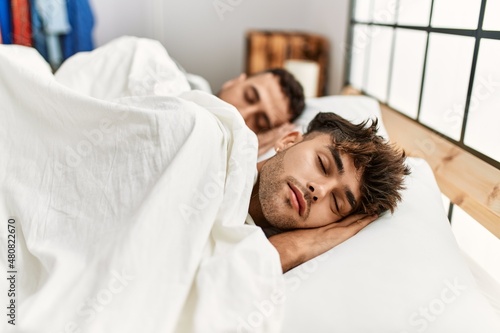 Two hispanic men couple sleeping at bedroom