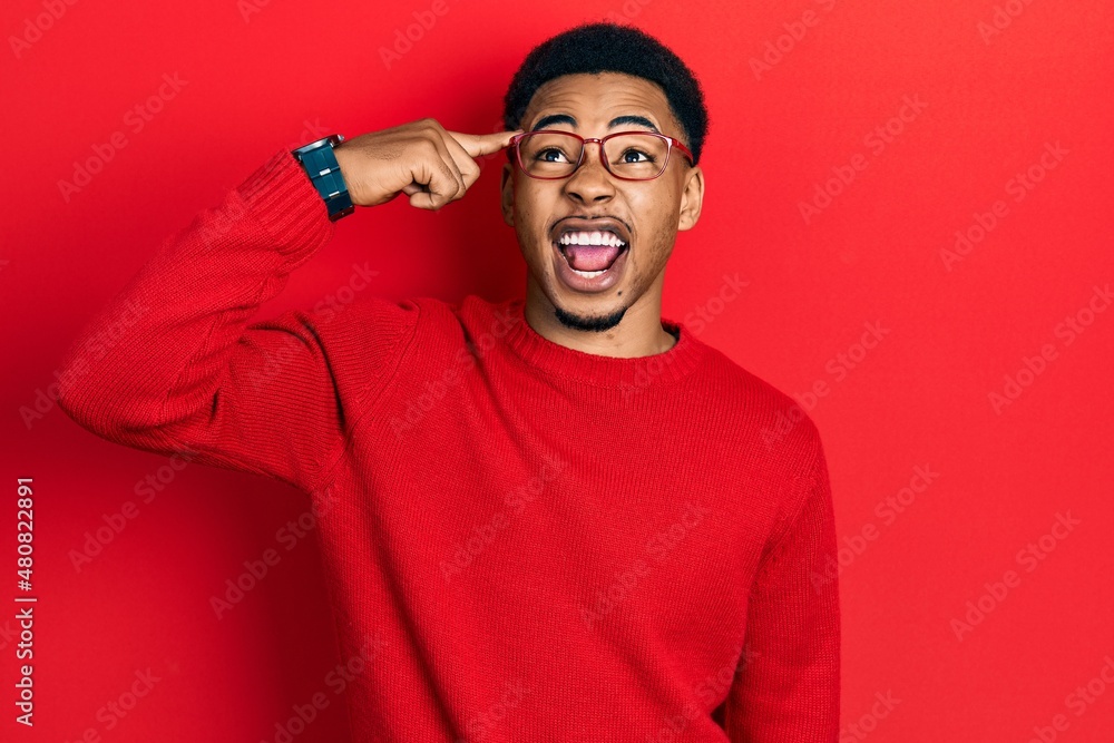 Young african american man pointing head with finger angry and mad screaming frustrated and furious, shouting with anger looking up. Young african american man pointing head with finger angry and mad screaming frustrated and furious, shouting with anger looking up.