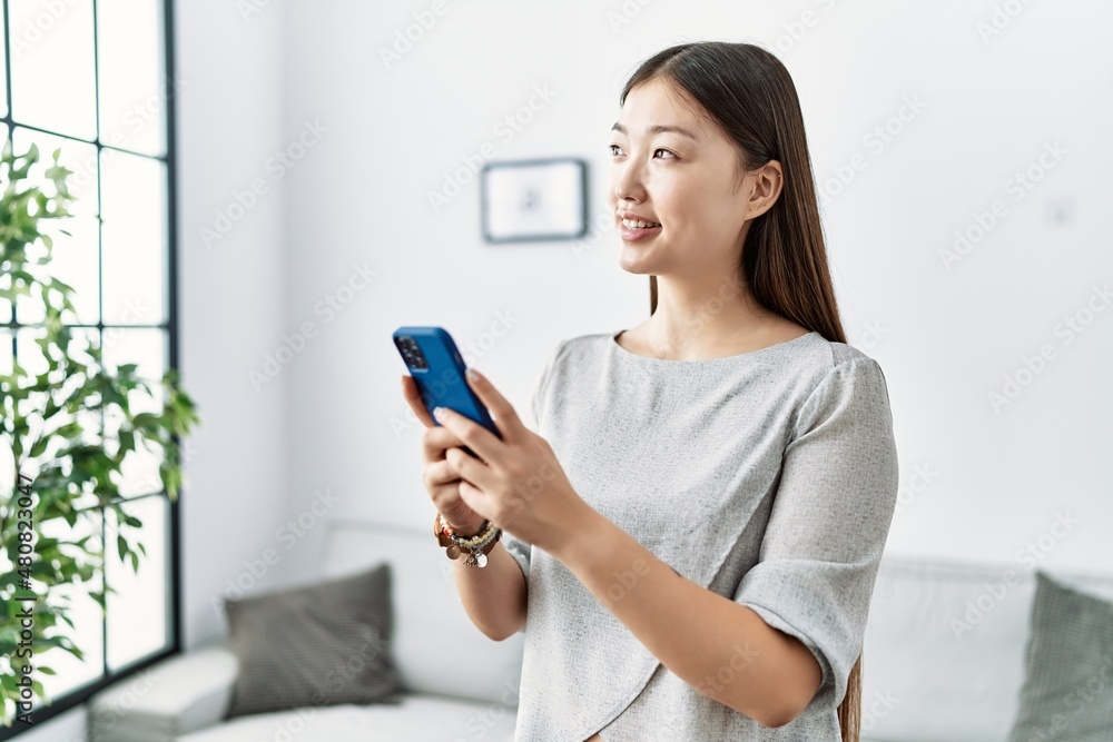 Young asian woman using smartphone at the living room Young asian woman using smartphone at the living room