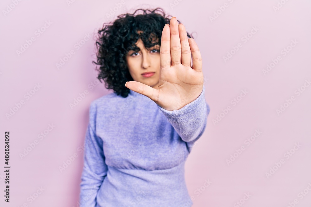 Young middle east woman wearing casual clothes doing stop sing with palm of the hand. warning expression with negative and serious gesture on the face. Young middle east woman wearing casual clothes doing stop sing with palm of the hand. warning expression with negative and serious gesture on the face.