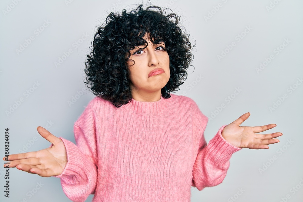Young middle east woman wearing casual clothes clueless and confused with open arms, no idea concept.