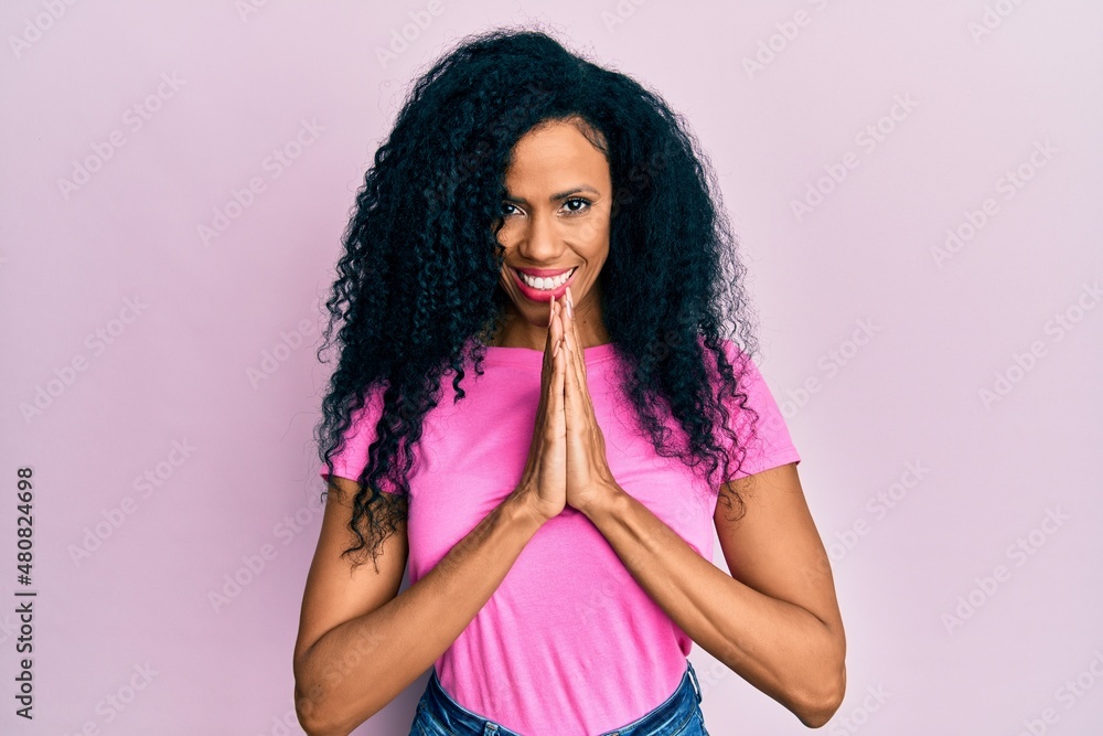 Middle age african american woman wearing casual clothes praying with hands together asking for forgiveness smiling confident. Middle age african american woman wearing casual clothes praying with hands together asking for forgiveness smiling confident.