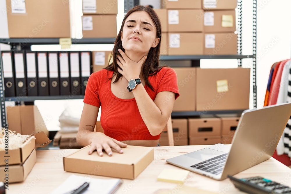 Young hispanic woman preparing order working at storehouse touching painful neck, sore throat for flu, clod and infection Young hispanic woman preparing order working at storehouse touching painful neck, sore throat for flu, clod and infection