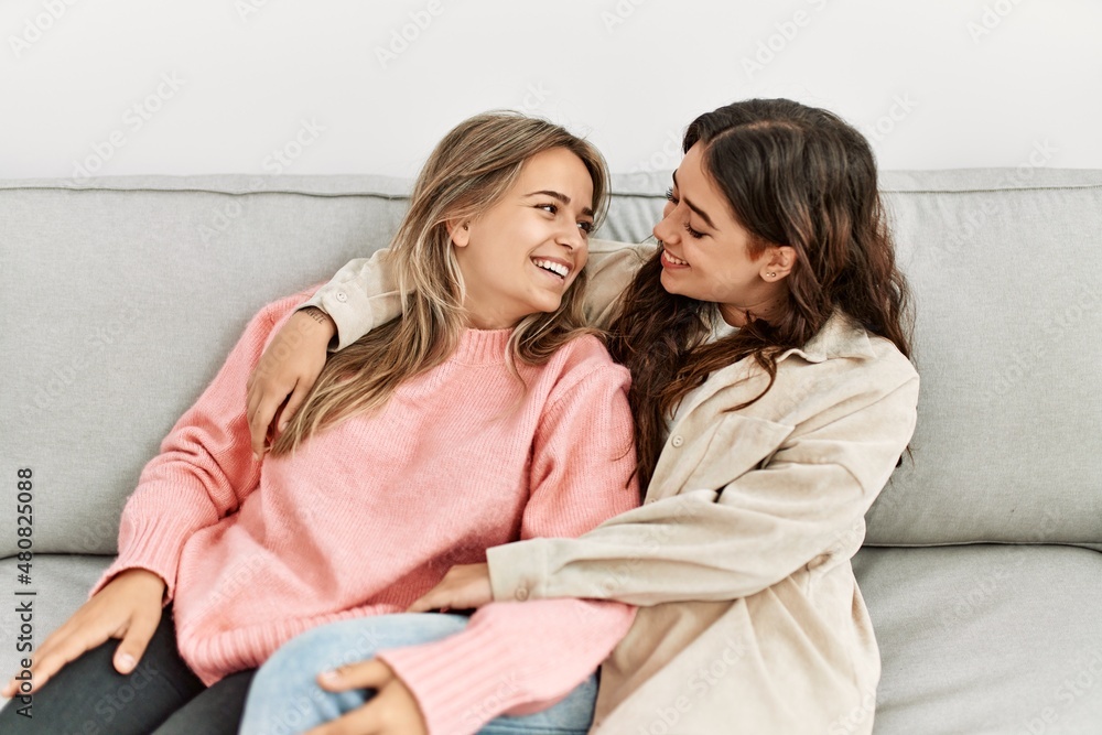Young beautiful couple sitting on the sofa hugging at home. Young beautiful couple sitting on the sofa hugging at home.