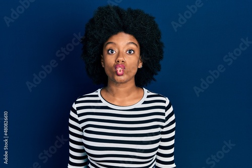 Young african american woman wearing casual clothes making fish face with lips, crazy and comical gesture. funny expression.