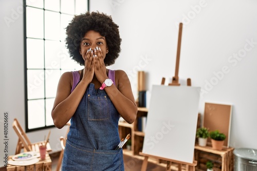 Bilde på lerret Young african american woman with afro hair at art studio laughing and embarrass