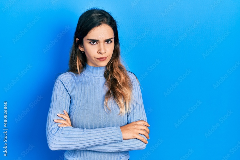 Young hispanic girl wearing casual clothes skeptic and nervous, disapproving expression on face with crossed arms. negative person. Young hispanic girl wearing casual clothes skeptic and nervous, disapproving expression on face with crossed arms. negative person.