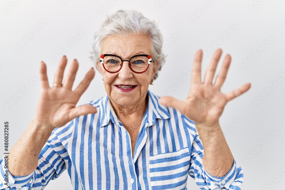 Senior woman with grey hair standing over white background showing and pointing up with fingers number ten while smiling confident and happy. Senior woman with grey hair standing over white background showing and pointing up with fingers number ten while smiling confident and happy.
