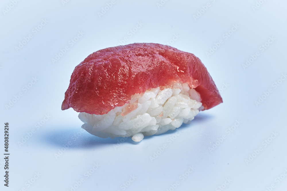 Single tuna nigiri sushi over blue background Single tuna nigiri sushi over blue background