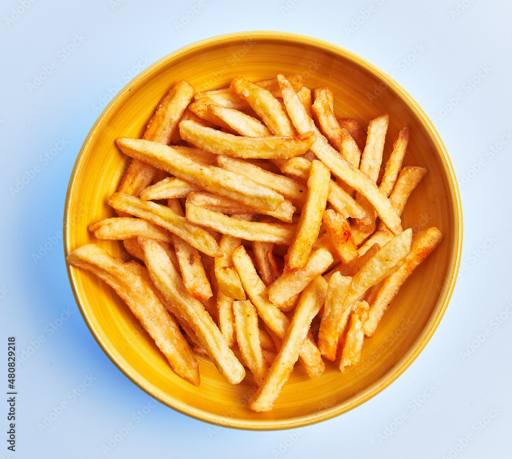 Bowl of french fried potatoes over blue background Bowl of french fried potatoes over blue background
