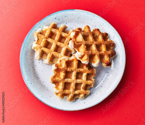  Plate of delicious waffles over red background