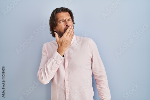 Handsome middle age man wearing elegant shirt background bored yawning tired covering mouth with hand. restless and sleepiness.