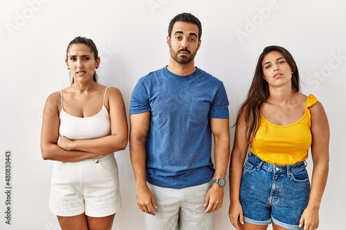 Group of young hispanic people standing over isolated background looking sleepy and tired  exhausted for fatigue and hangover  lazy eyes in the morning.
