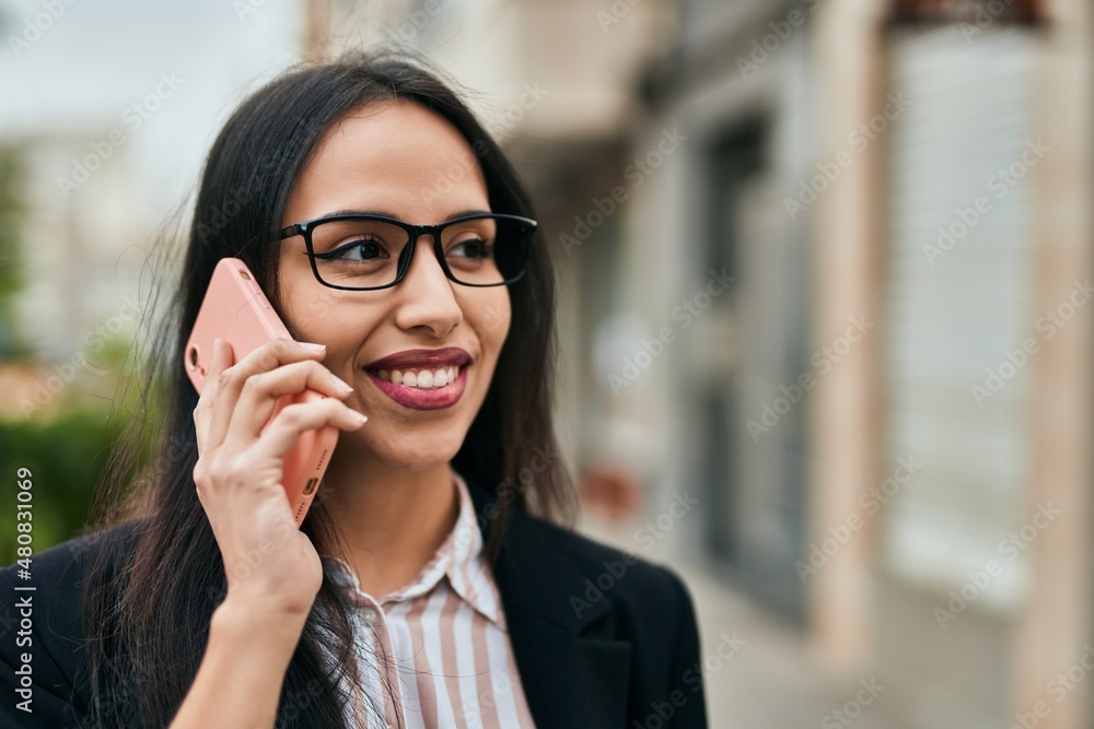 Young hispanic businesswoman smiling happy talking on the smartphone at the city. Young hispanic businesswoman smiling happy talking on the smartphone at the city.
