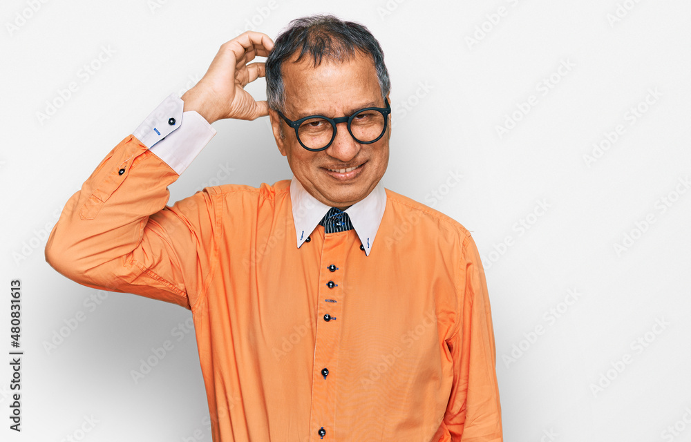 Middle age indian man wearing casual clothes and glasses confuse and wonder about question. uncertain with doubt, thinking with hand on head. pensive concept. Middle age indian man wearing casual clothes and glasses confuse and wonder about question. uncertain with doubt, thinking with hand on head. pensive concept.