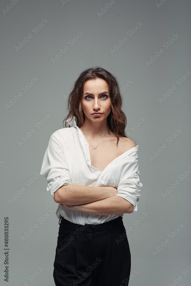 Confident pretty woman posing in black pants with a high waist and a white shirt. Business woman concept. Confident pretty woman posing in black pants with a high waist and a white shirt. Business woman concept.