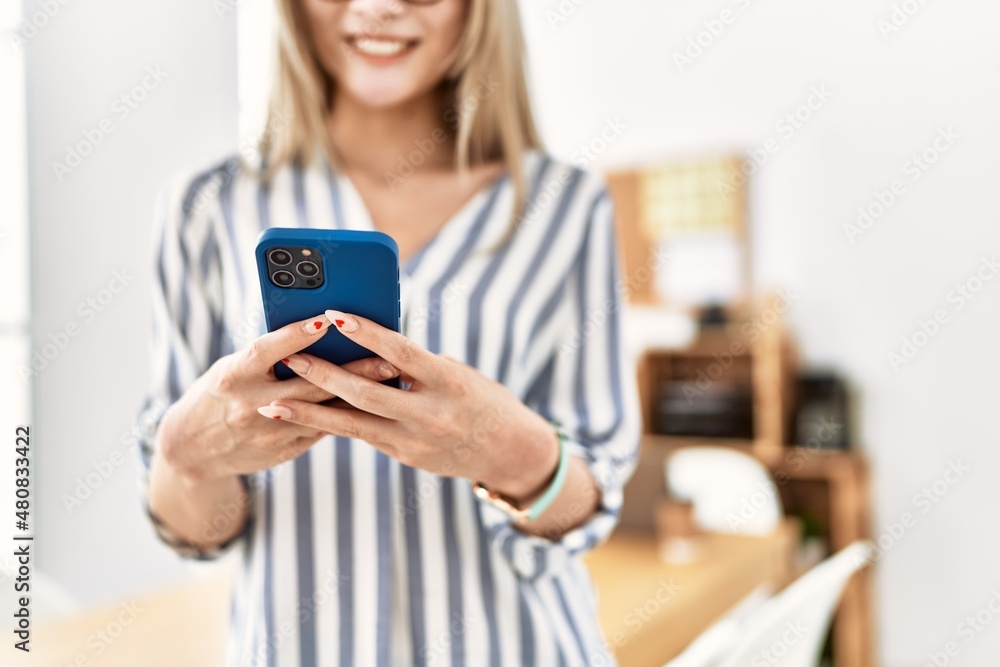 Young chinese woman smiling confident using smartphone at office