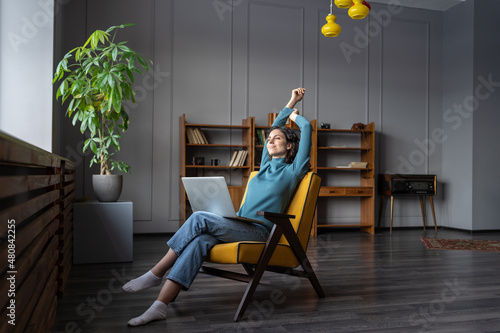 Photography Young satisfied woman remote worker relaxing, stretching arms while working from