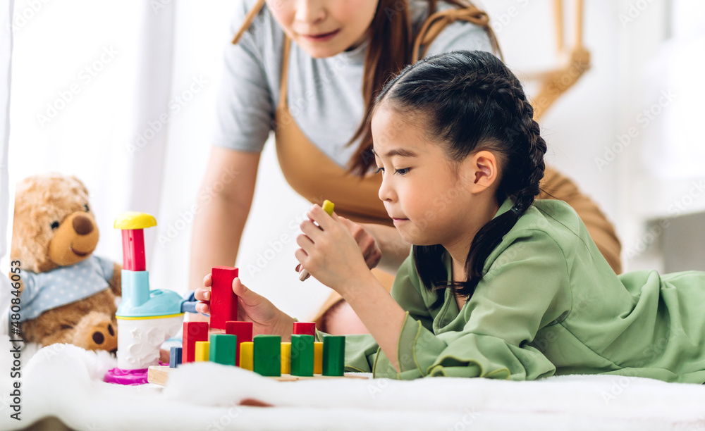 Obraz premium Portrait of enjoy happy love asian family mother and little asian girl smiling activity learn and skill brain training play with toy build wooden blocks board education game at home
