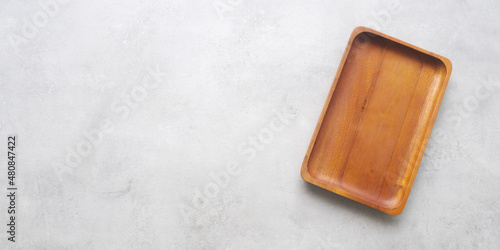 Empty wooden plate on gray cement table background, banner with copy space, Blank wood tray for food display montage, template, mock up, top view, flat lay
