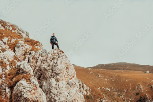 A male hiker standing on the mountain peak cliff adventure travel.