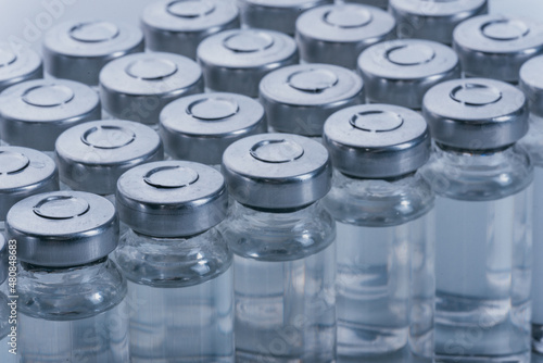 Glass medical ampoule vial for injection. Medicine is dry white drug penicillin powder or liquid with of aqueous solution in ampulla. Close up.