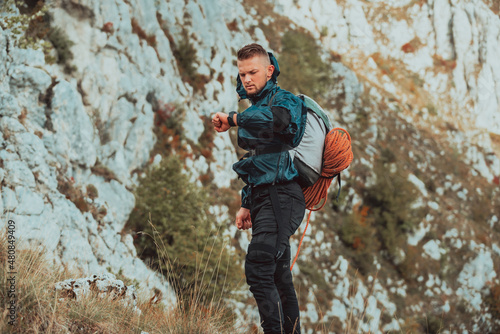 Bild auf Leinwand A male hiker looking at monitor watch checking heart rate during hiking on the mountain adventure travel extreme sport outdoor active lifestyle