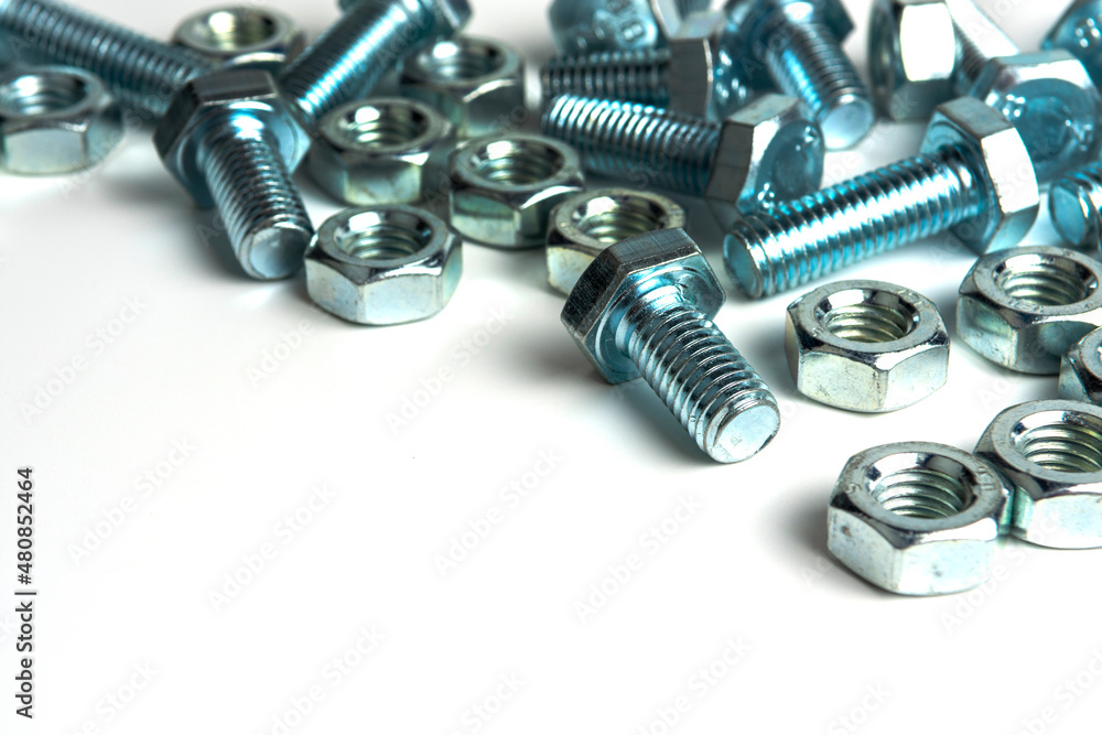 several metal bolts with washers and nuts on a white background. close-up several metal bolts with washers and nuts on a white background. close-up