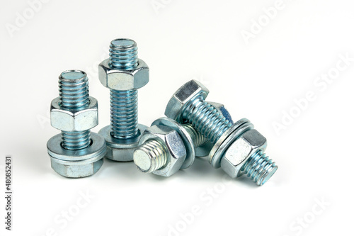 several metal bolts with washers and nuts on a white background. close-up
