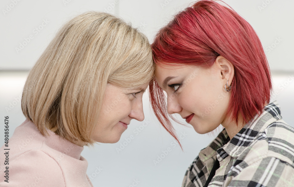 Happy loving mother and teen daughter smile and having fun at home spending time together Happy loving mother and teen daughter smile and having fun at home spending time together