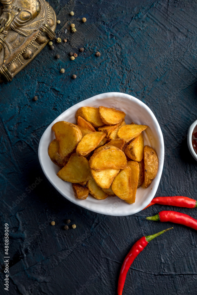 Fototapeta premium Deep-fried potato wedges with paprika and red sauce. Decorated in Asian style.