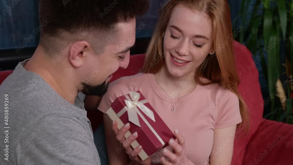 Caucasian man is giving his girlfriend a gift box. Christmas surprise present. Birthday, christmas, valentine. Xmas portrait. Caucasian man is giving his girlfriend a gift box. Christmas surprise present. Birthday, christmas, valentine. Xmas portrait.