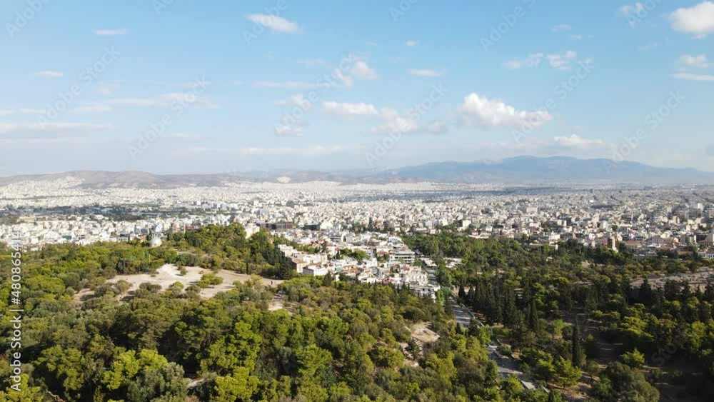 Athens Greece cityscape skyline, drone aerial view of buildings under hill with green forest on sunny summer day Athens Greece cityscape skyline, drone aerial view of buildings under hill with green forest on sunny summer day