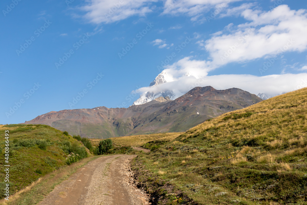 A panoramic hiking trail leading to the Koruldi Lakes in the Greater Caucasus Mountain Range in Georgia, Upper Svanet Region. Panoramic view on the Ushba mountain peaks. Wanderlust. Remote location.