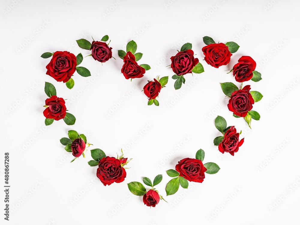 Heart-shaped wreath made of red roses. Floral composition on a light background. Top view Heart-shaped wreath made of red roses. Floral composition on a light background. Top view